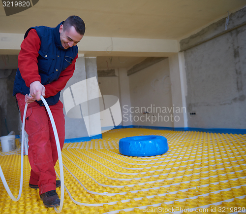 Image of workers installing underfloor heating system