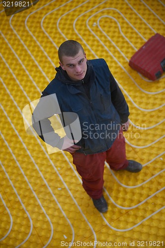 Image of workers installing underfloor heating system