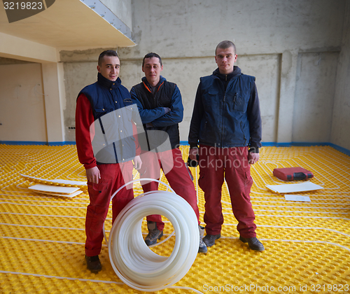 Image of workers installing underfloor heating system