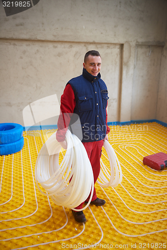 Image of workers installing underfloor heating system