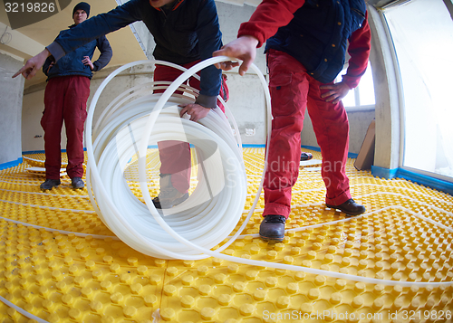 Image of workers installing underfloor heating system