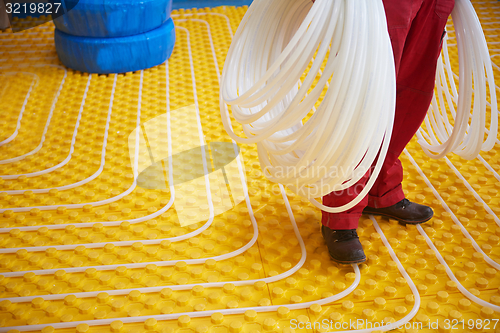 Image of workers installing underfloor heating system