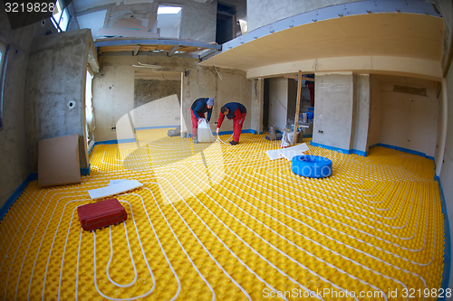 Image of workers installing underfloor heating system