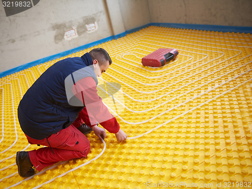 Image of workers installing underfloor heating system