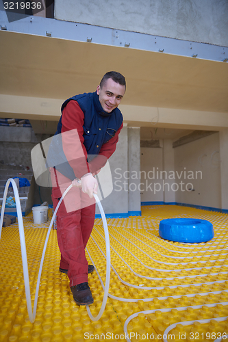 Image of workers installing underfloor heating system