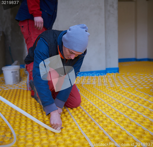 Image of workers installing underfloor heating system