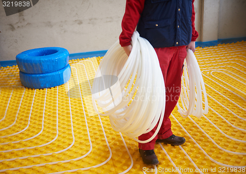 Image of workers installing underfloor heating system