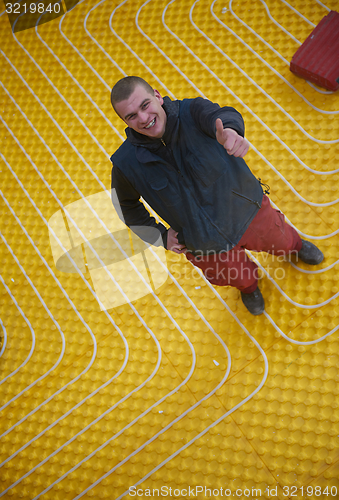 Image of workers installing underfloor heating system