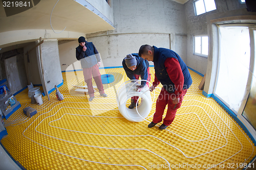 Image of workers installing underfloor heating system