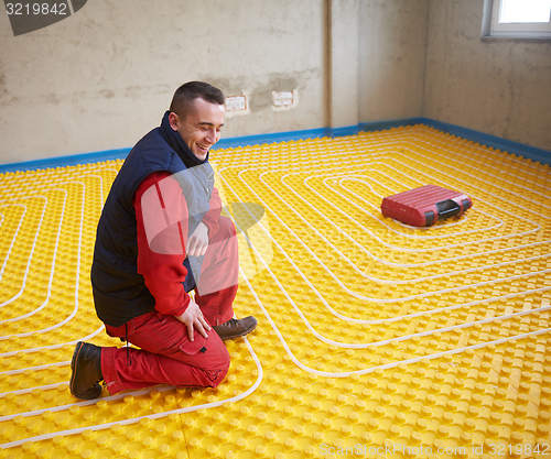Image of workers installing underfloor heating system