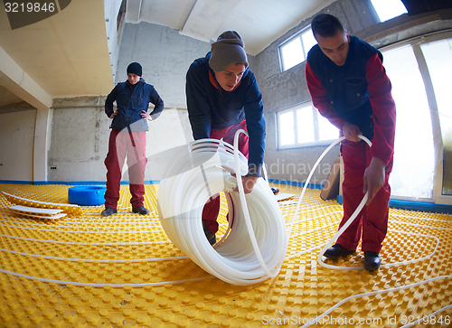 Image of workers installing underfloor heating system