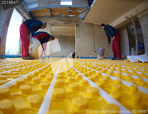 Image of workers installing underfloor heating system