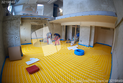 Image of workers installing underfloor heating system