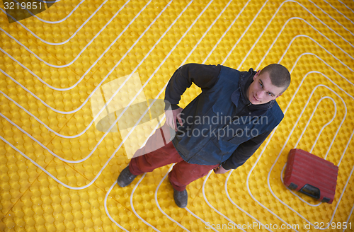 Image of workers installing underfloor heating system