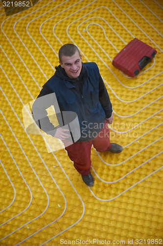 Image of workers installing underfloor heating system