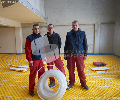 Image of workers installing underfloor heating system