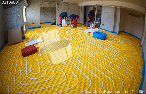 Image of workers installing underfloor heating system