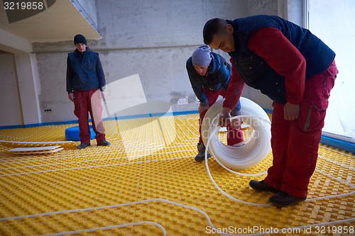 Image of workers installing underfloor heating system