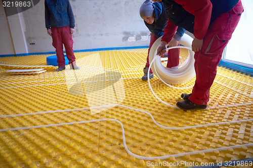 Image of workers installing underfloor heating system