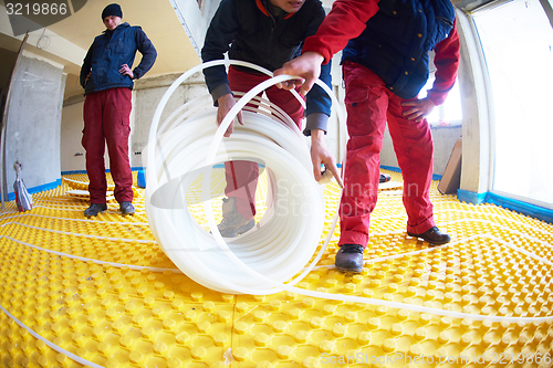 Image of workers installing underfloor heating system