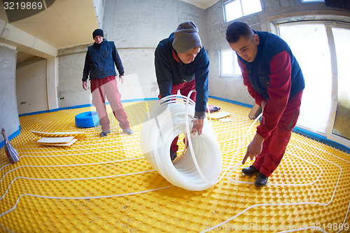 Image of workers installing underfloor heating system