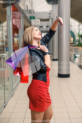 Image of beautiful young woman goes shopping