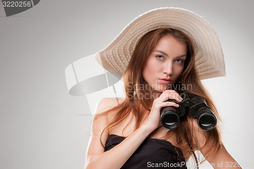 Image of Young woman in hat with binoculars