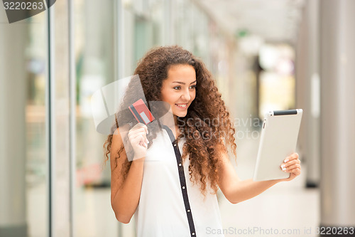 Image of Beautiful young girl paying by credit card for shopping 