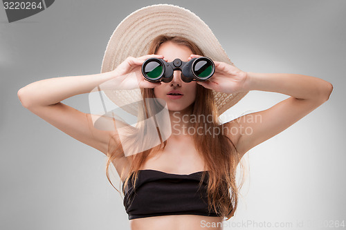 Image of Young woman in hat with binoculars