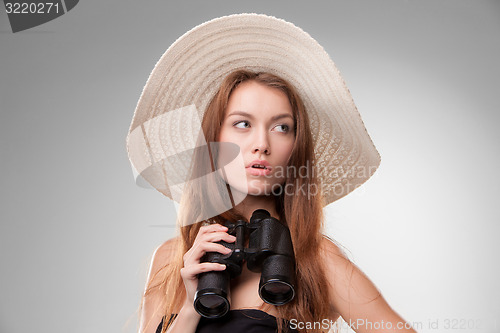 Image of Young woman in hat with binoculars