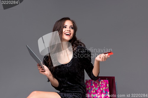 Image of Beautiful young girl paying by credit card for shopping 