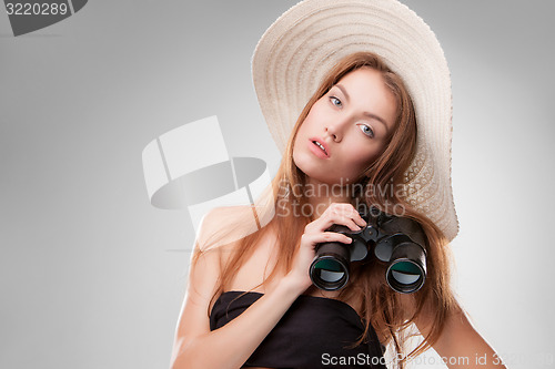Image of Young woman in hat with binoculars