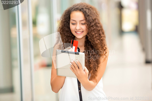 Image of Beautiful young girl paying by credit card for shopping 