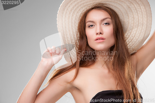 Image of Beautiful girl with hat posing in studio