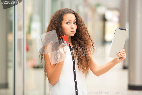 Image of Beautiful young girl paying by credit card for shopping 