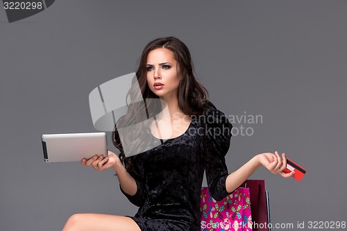 Image of Beautiful young girl paying by credit card for shopping 