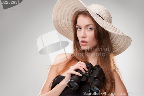 Image of Young woman in hat with binoculars