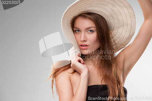 Image of Beautiful girl with hat posing in studio