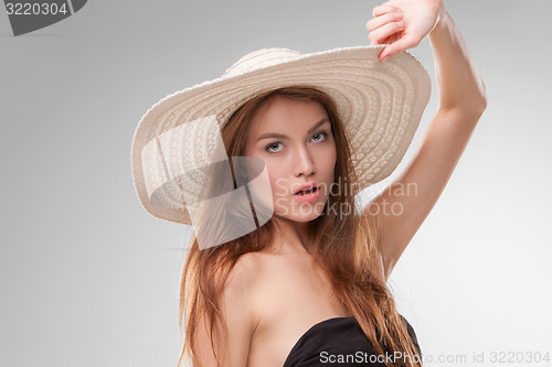 Image of Beautiful girl with hat posing in studio