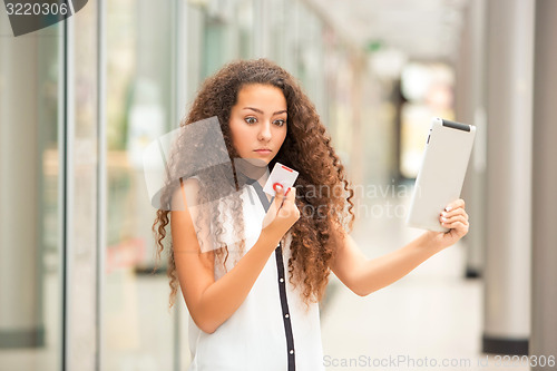 Image of Beautiful young girl paying by credit card for shopping 