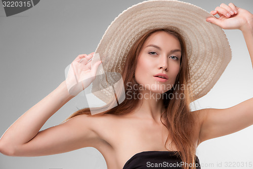 Image of Beautiful girl with hat posing in studio