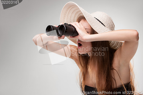 Image of Young woman in hat with binoculars