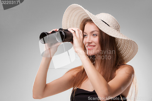 Image of Young woman in hat with binoculars
