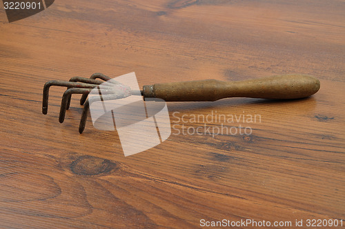 Image of Hand rake on wood