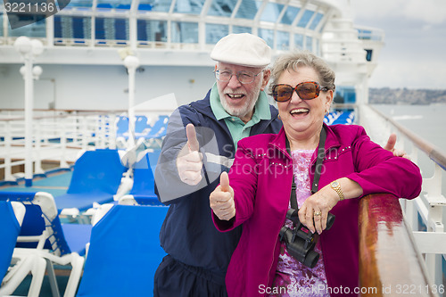 Image of Senior Couple With Thumbs Up on Deck of Cruise Ship