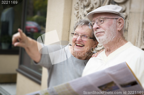 Image of Tourist Senior Couple Looking at Brochure Map