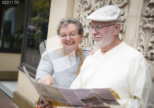 Image of Tourist Senior Couple Looking at Brochure Map