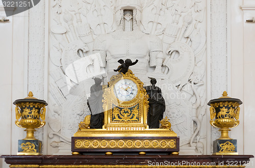 Image of Antique clock in gold case in the interior Hermitage Museum