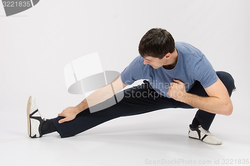 Image of Athlete crouching pulling muscles of the right leg