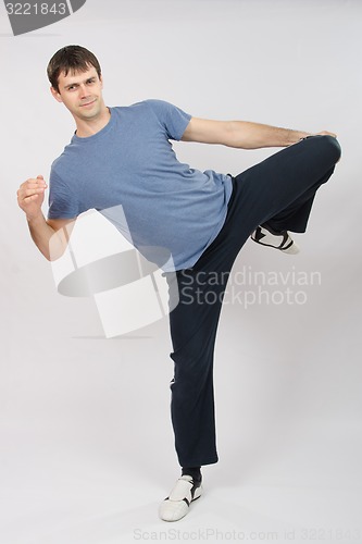 Image of Young man flexing muscles of the legs
